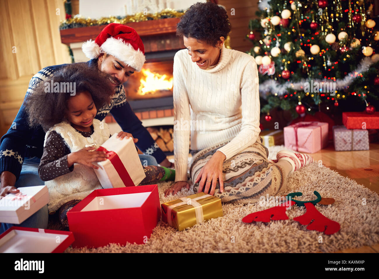 Happy afro American family in Christmas morning opening present Stock Photo