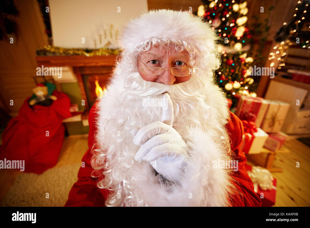 Real Santa Claus gesturing shhh with finger on mouth Stock Photo