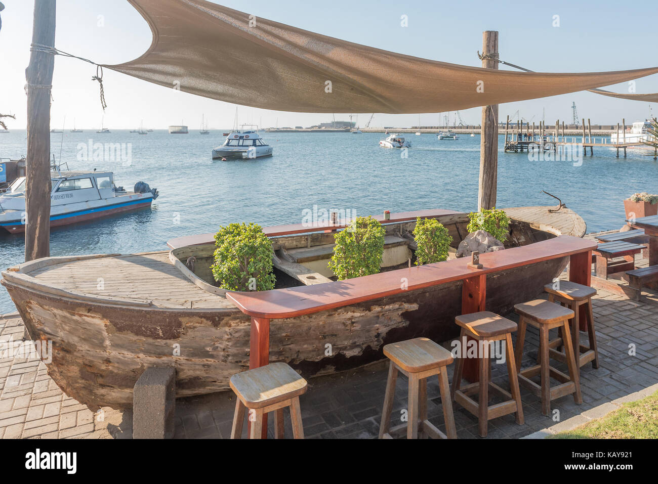 WALVIS BAY, NAMIBIA - JULY 1, 2017: A boat used as restaurant table at the watefront in Walvis Bay on the Atlantic Coast of Namibia Stock Photo