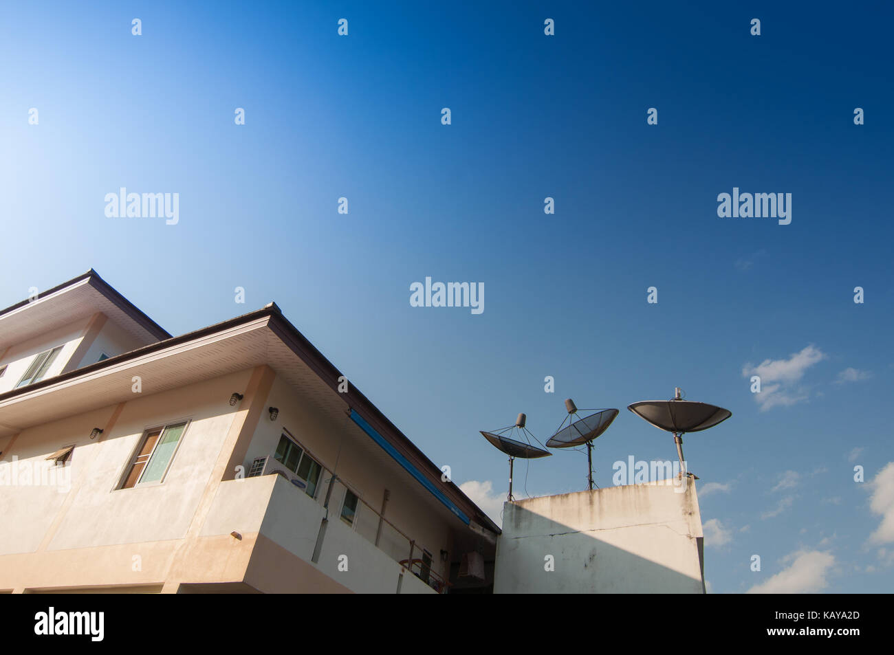 Home and receiver satlelite on a roof with Blue sky cloudy backgrounds Stock Photo