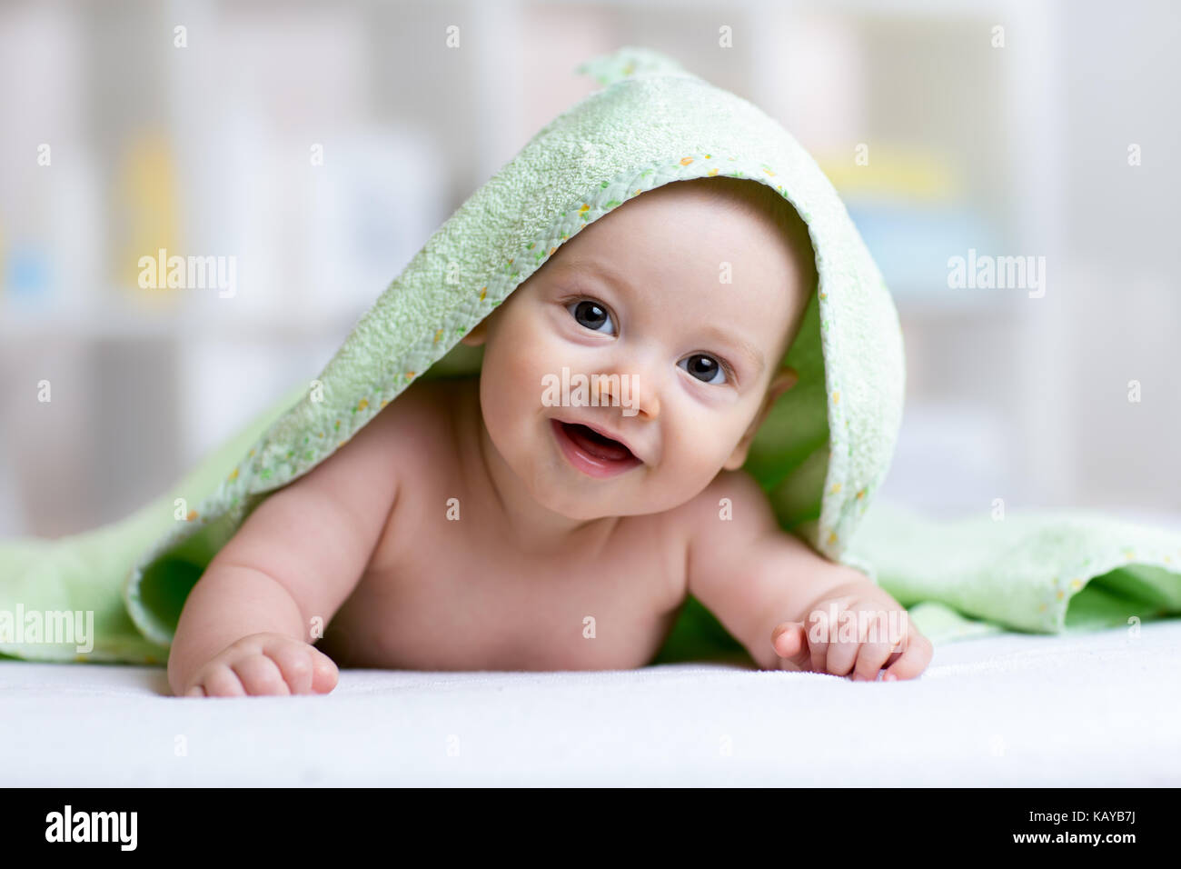 cute baby in green towel after bathing Stock Photo