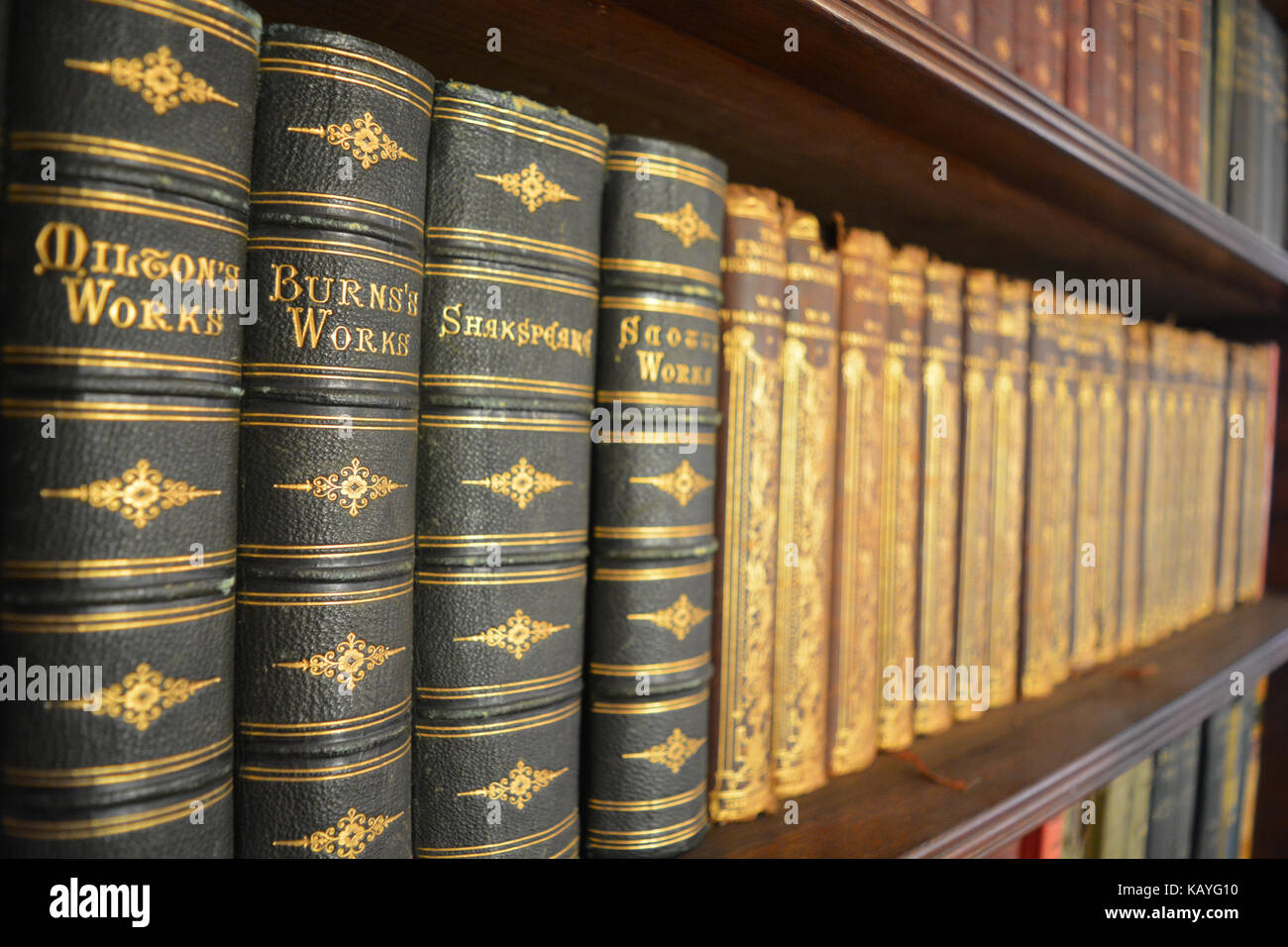 Antique books on a shelf in a bookcase Stock Photo