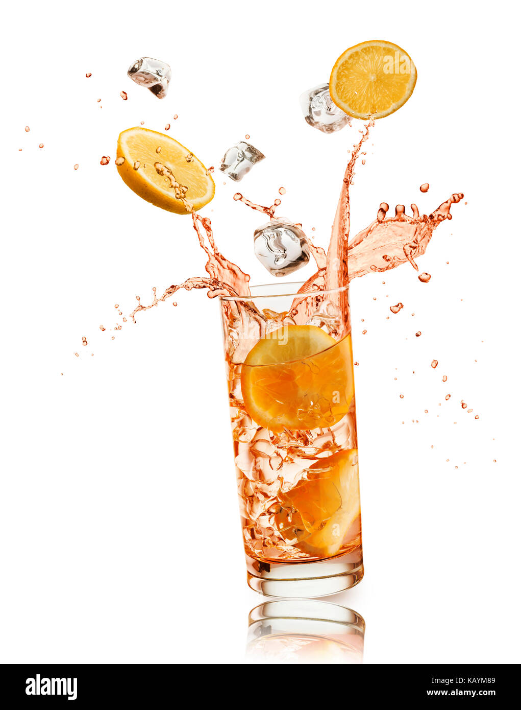 glass full of orange drink with orange slices and ice cubes falling and splashing, on white background Stock Photo