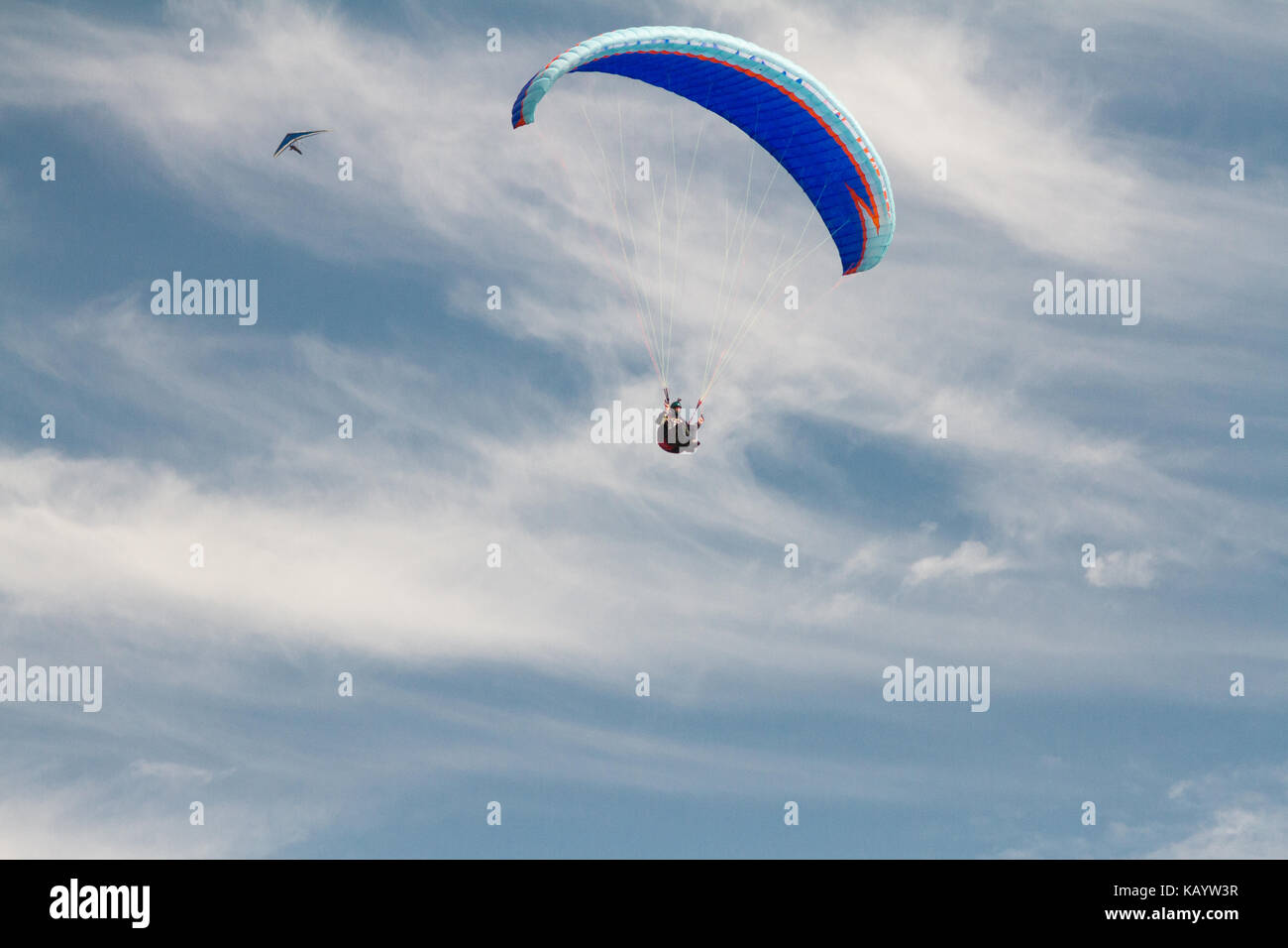 A paraglider up in the sky during a fly, surrounded by the clouds