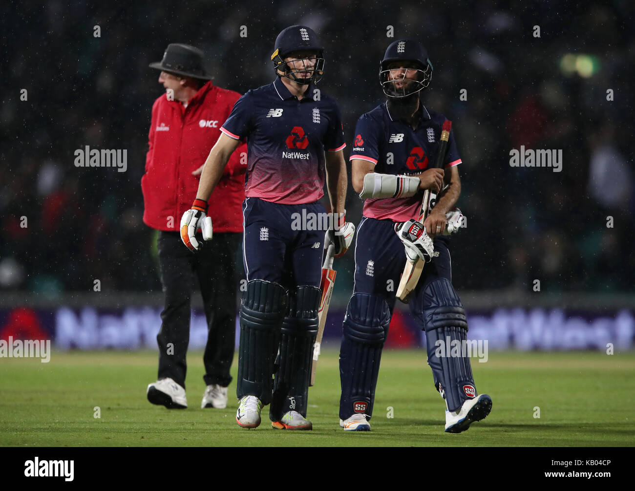 England's Jos Buttler and Moeen Ali (right) walk off as play is halted due to rain with England ahead on D/L during the Fourth Royal London One Day International at the Kia Oval, London. Stock Photo