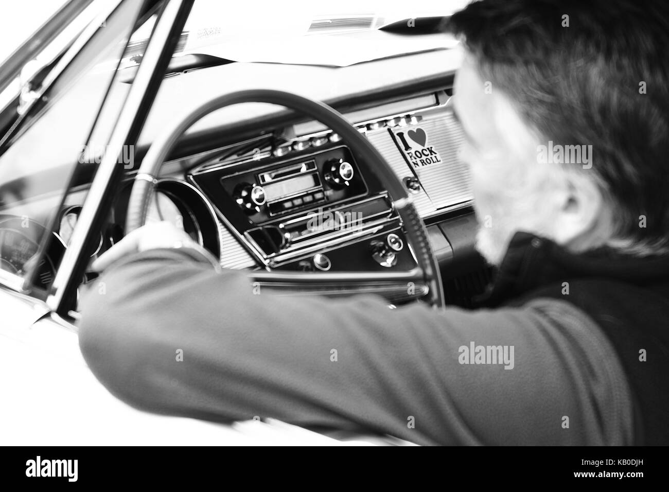 Man listening to Rock n Roll on radio in classic American car at Kop Hill Climb Stock Photo