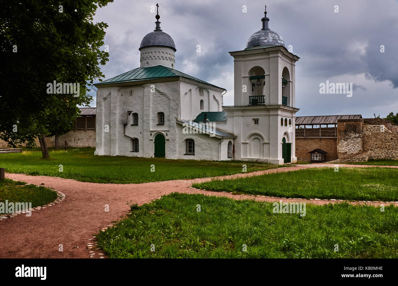 The Orthodox temple is located inside the ancient fortress. Near the church there is a white one-tiered bell tower. Russia, Pskov region, landscape Stock Photo
