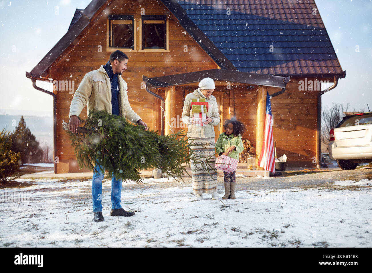 Afro American young Daddy holding Christmas tree for his little daughter Stock Photo