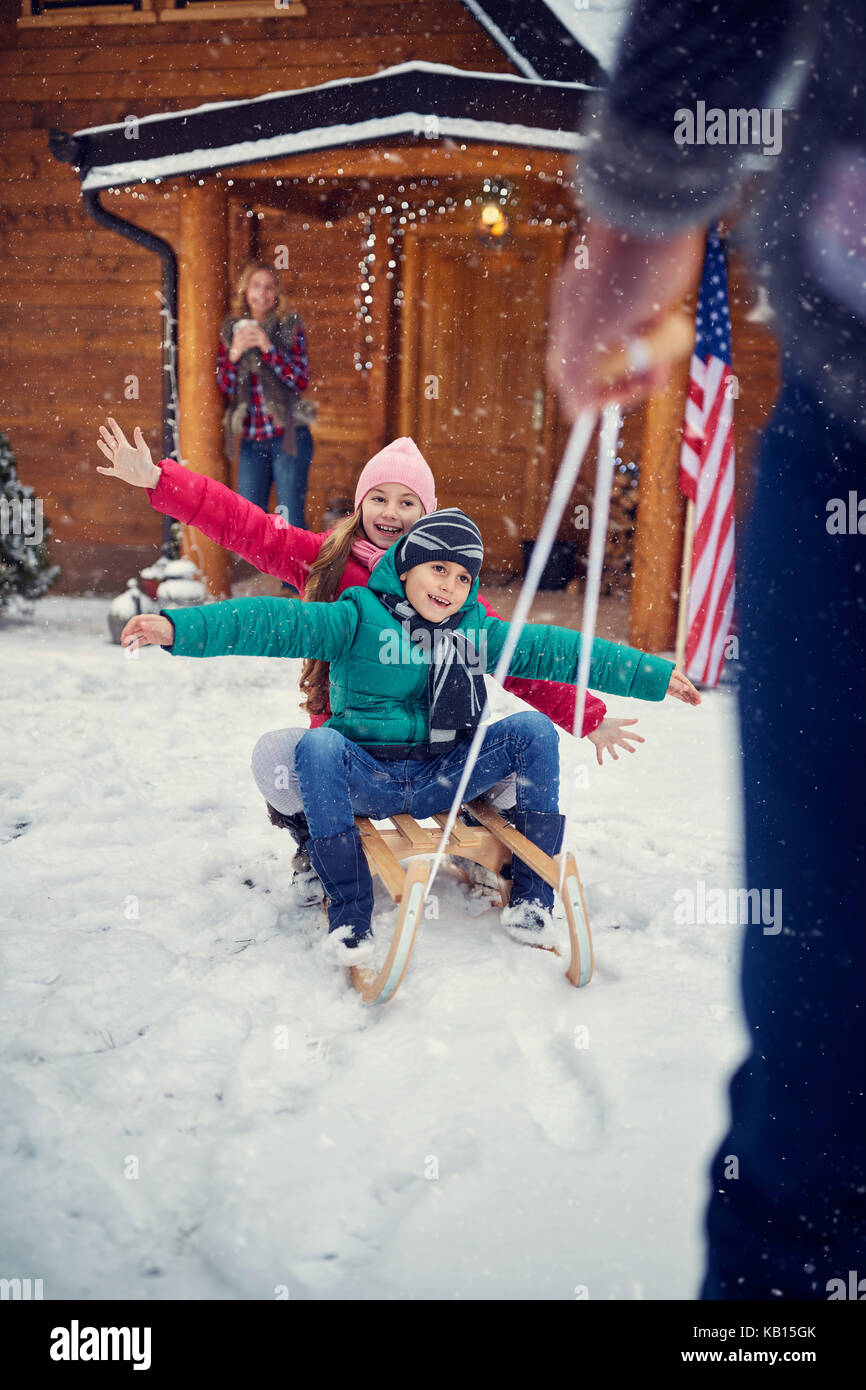 Winter fun – smiling children sledding Stock Photo