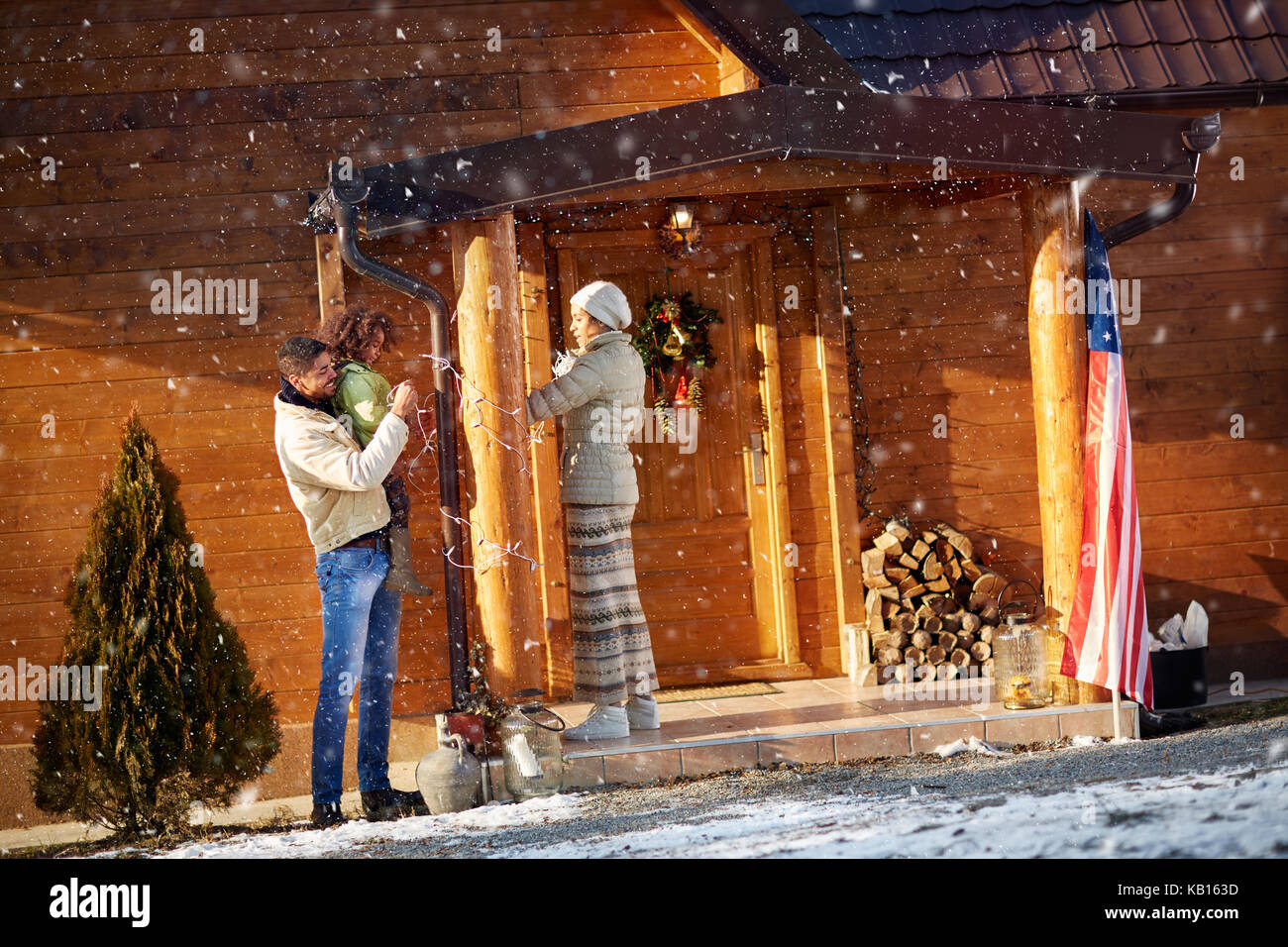 Happy Afro American family decorate wooden house for Christmas Stock Photo