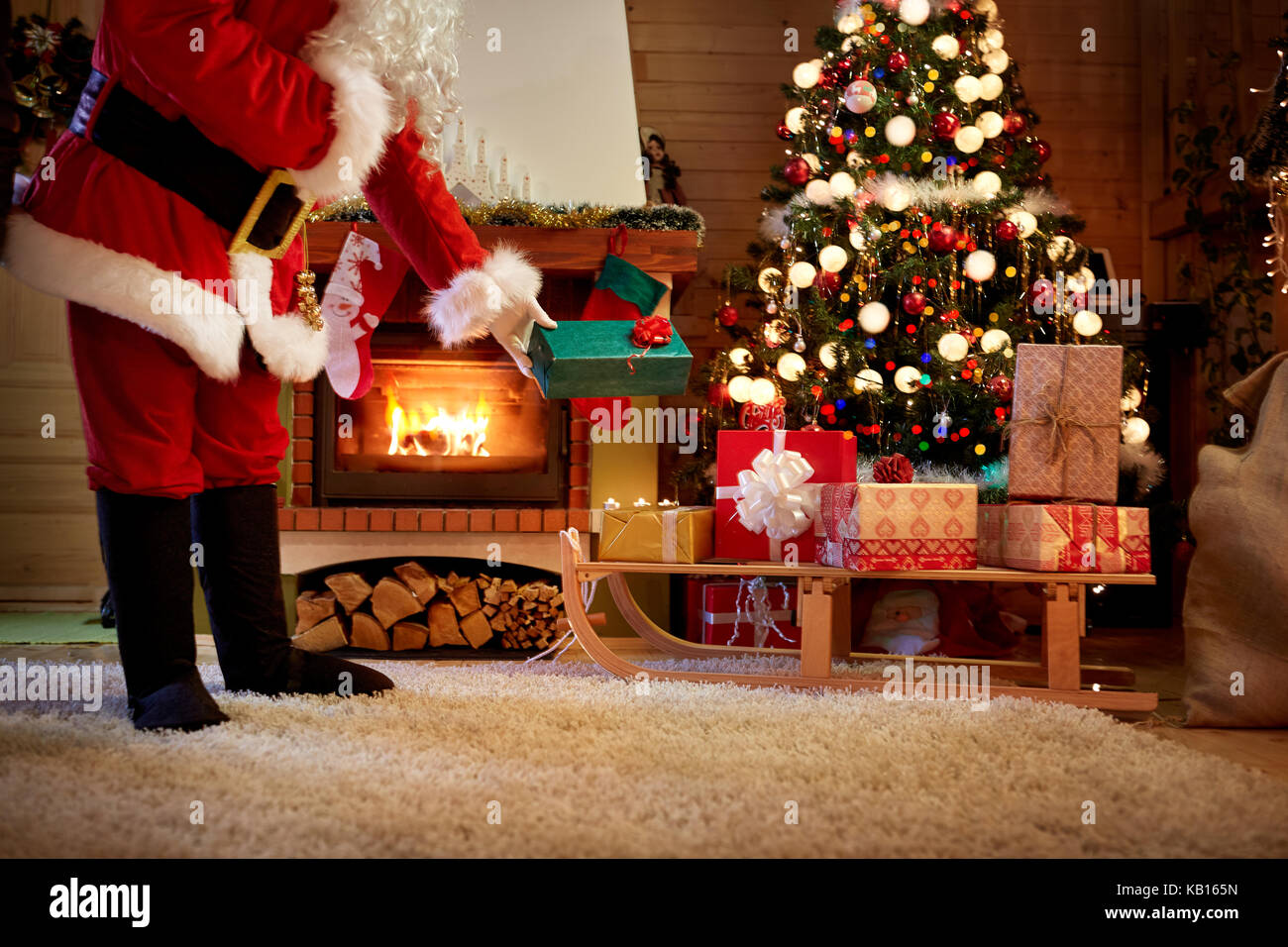 Santa Claus secretly leaves a gift under the Christmas tree Stock Photo ...