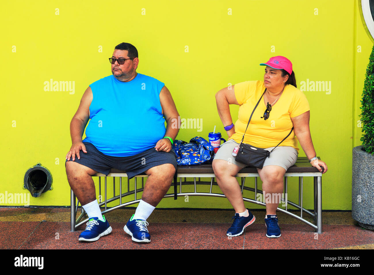 Overweight man and woman sitting on a bench, Orlando, Florida, USA Stock Photo