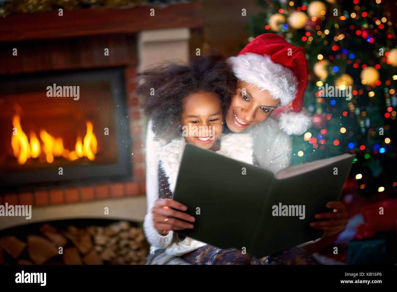 afro American mom and daughter enjoying in magic Christmas fairytales Stock Photo