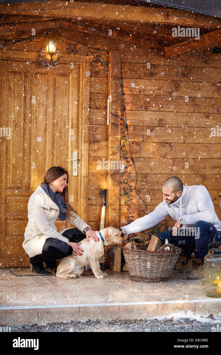 Happy girl with boyfriend and dog in front of weekend cottage Stock Photo -  Alamy