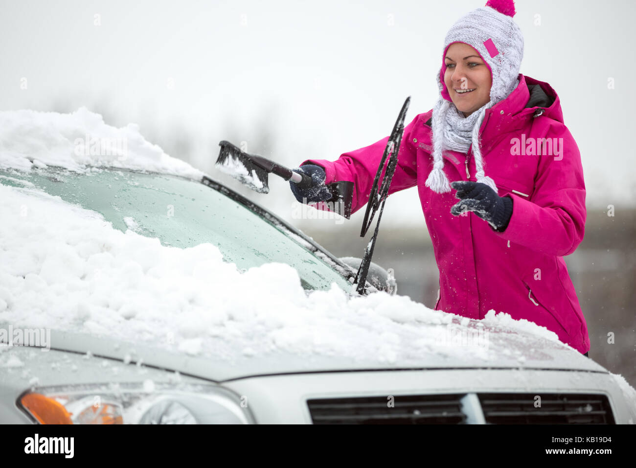 Woman cleaning car windshield of snow winter Stock Photo Alamy