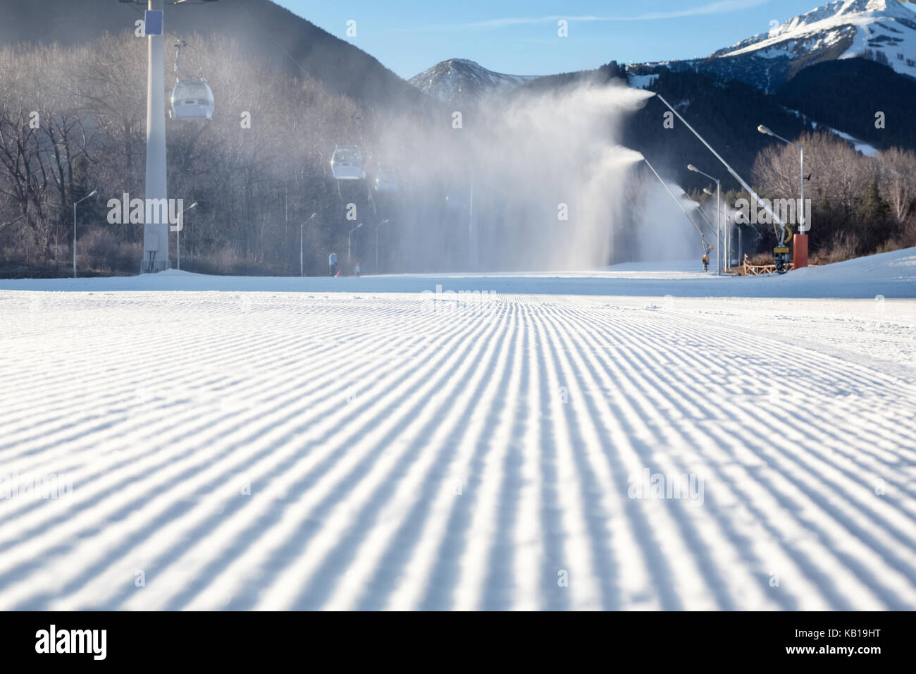 perfectly groomed empty ski run with snow cannon which is making powder snow Stock Photo
