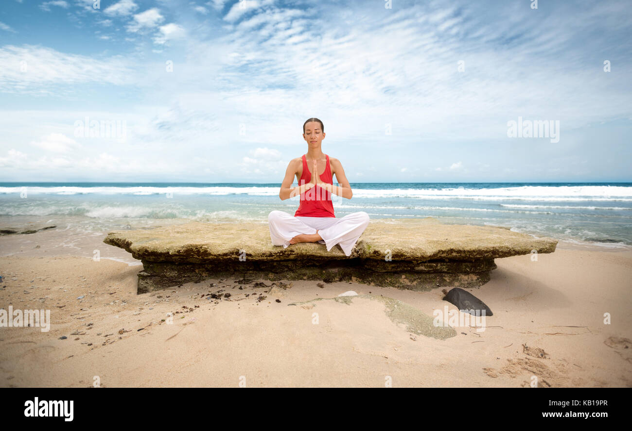 Meditation, young woman in lotus position on rock meditating Stock ...