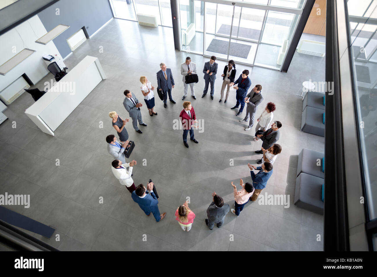 Top view of satisfied team clapping hands with manager in centre of circle Stock Photo