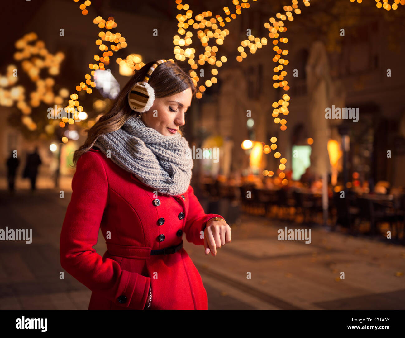 woman looking at her watch in street while waiting her boyfriend who is late for a date Stock Photo