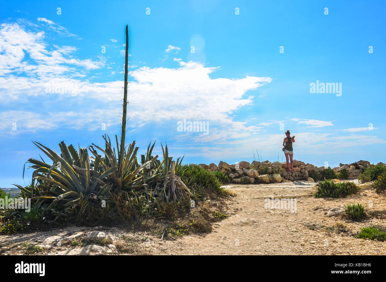 A woman and a footpath in Gozo's hot countryside, Malta Stock Photo