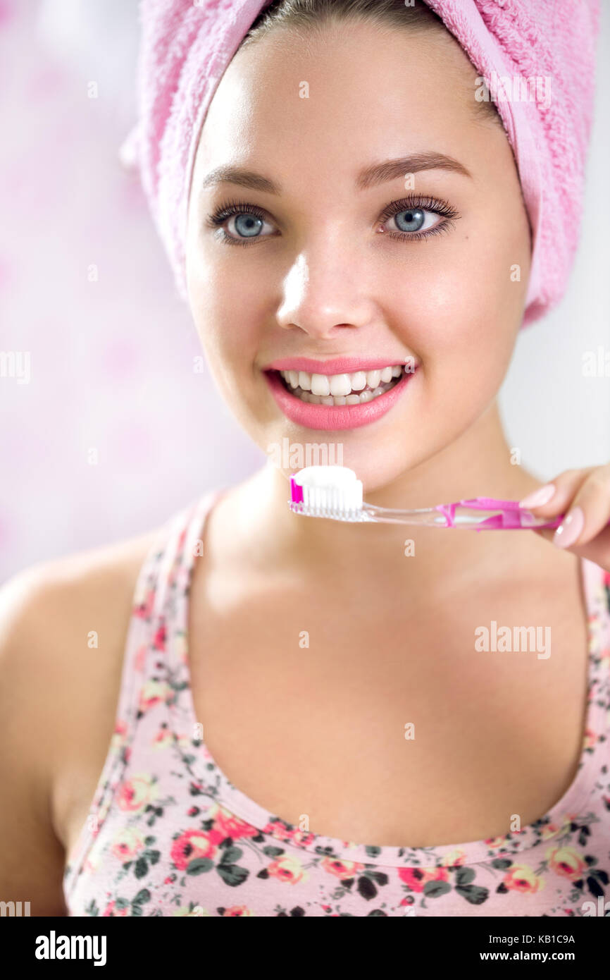 pretty girl brushing her teeth in front of mirror in the morning Stock Photo