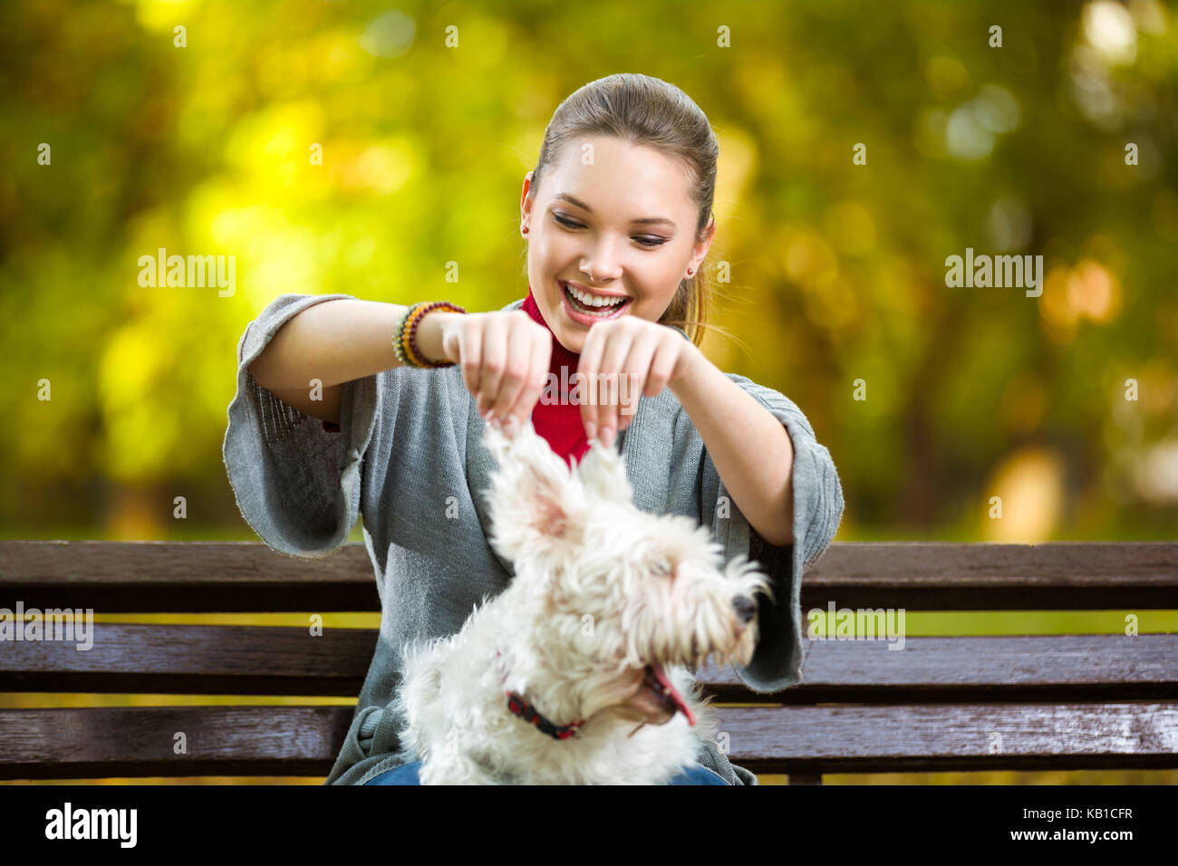 Fun young girl playing with her dog in autumn park Stock Photo - Alamy