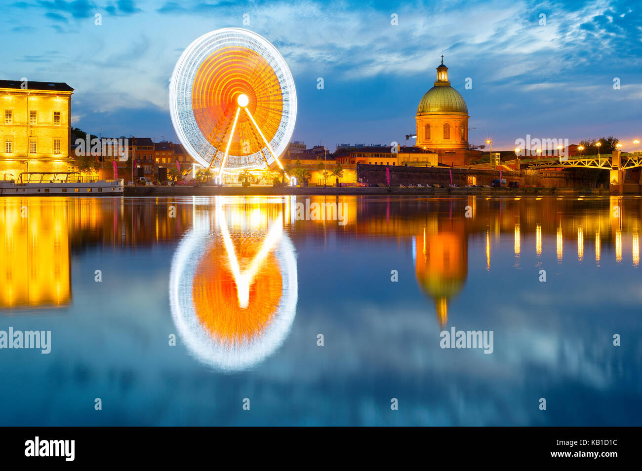 Twilight view of Hospital de La Grave and Ferries Wheel reflected in Garone river. Toulouse, France Stock Photo