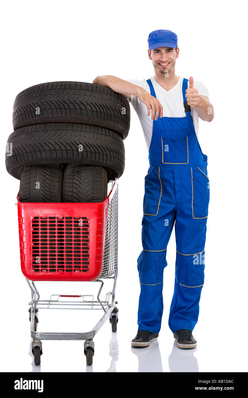 Young mechanic with tyre giving a thumbs up Stock Photo