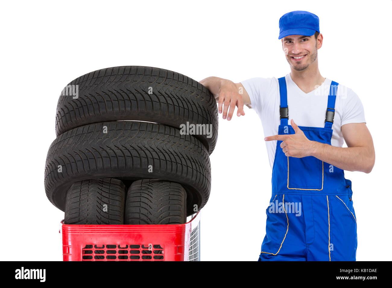 Cheerful mechanic pointing in new tires in shopping cart Stock Photo