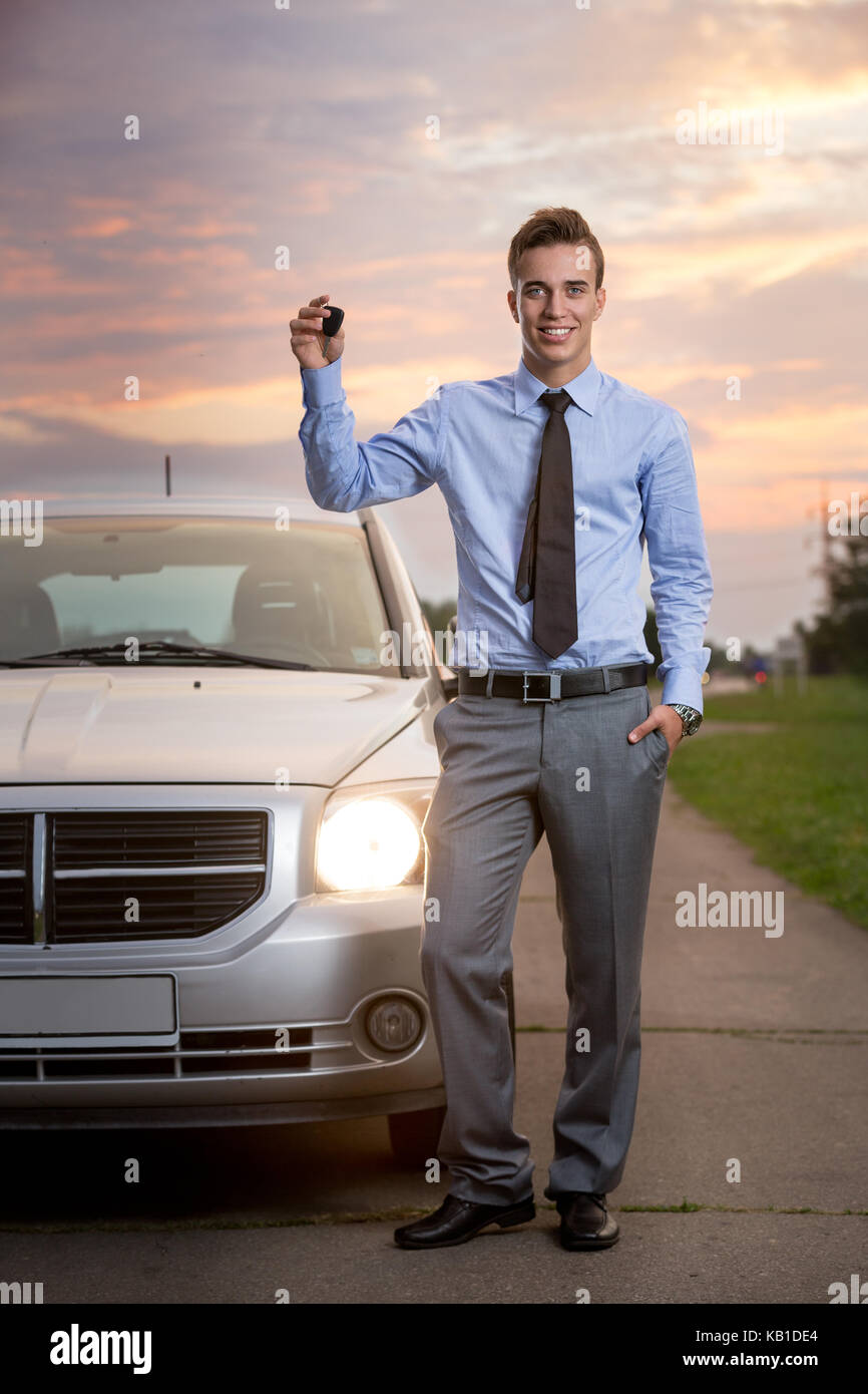 Smiling handsome man holding keys of new car Stock Photo - Alamy