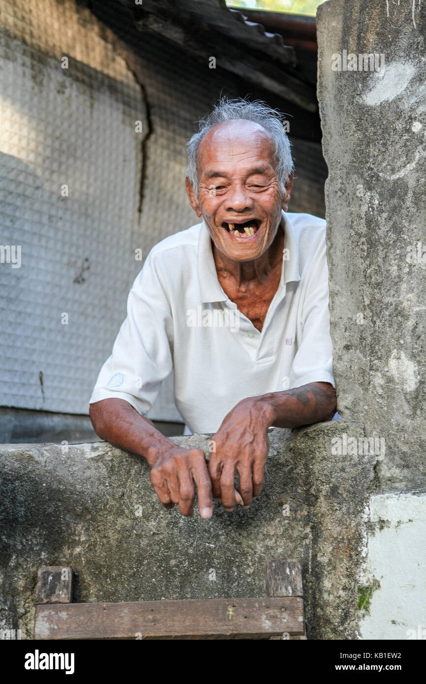 portrait of an old man with few teeth living in an above ground cemetery among the crypts in Bacolod City, Negros Occidental Island, Philippines. Stock Photo