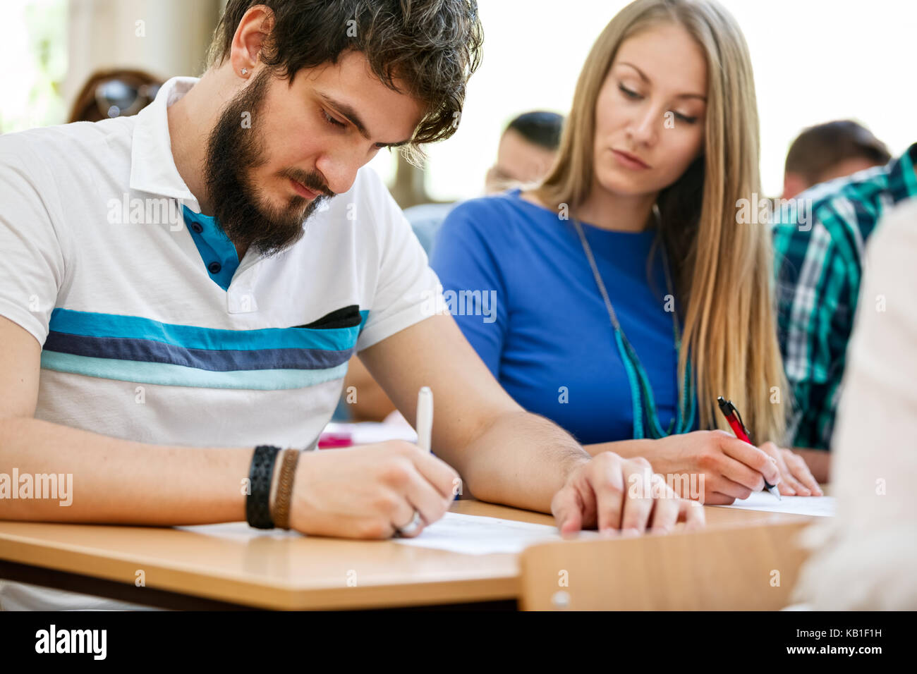 Female student looking at colleague test Stock Photo