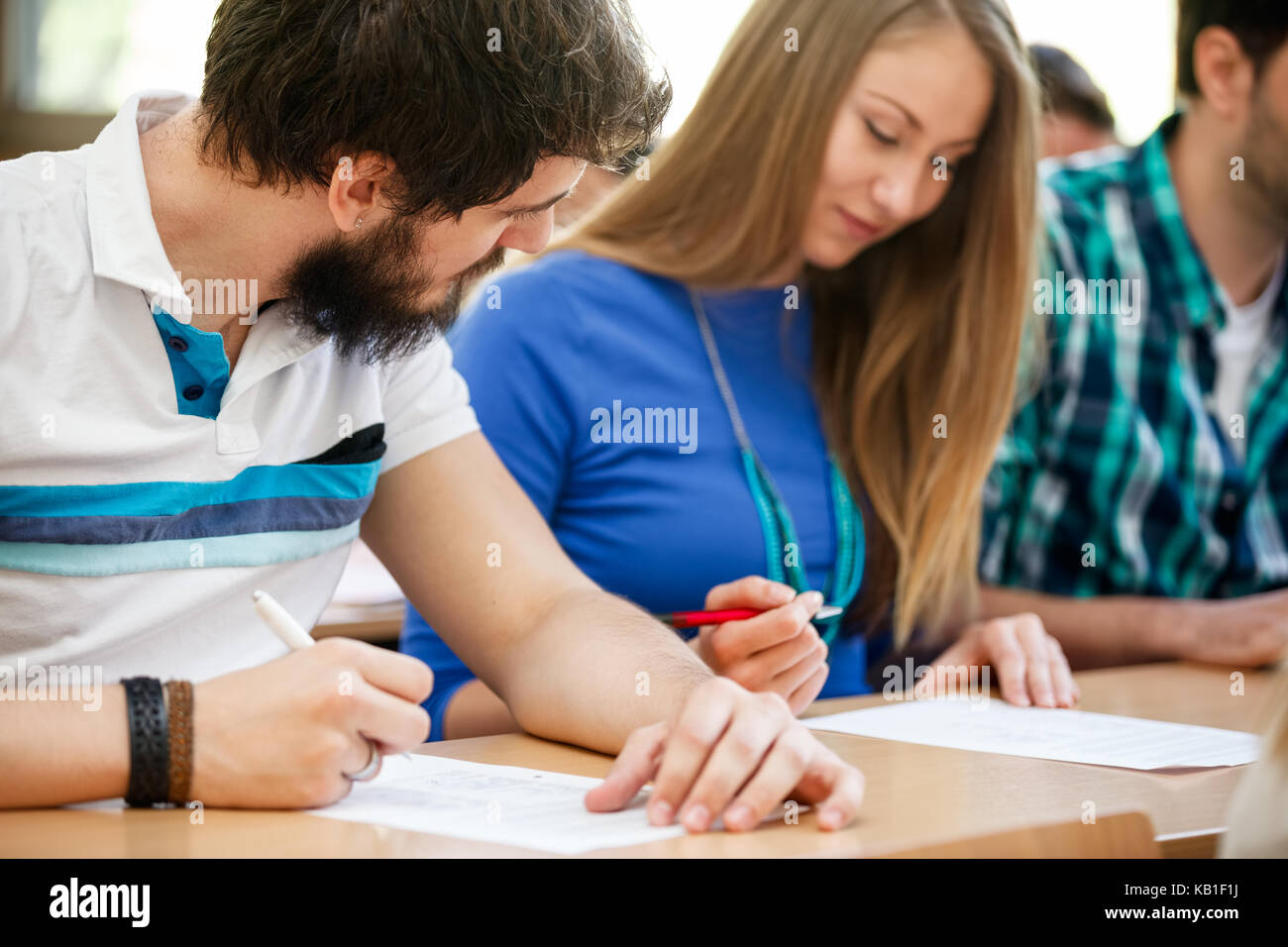 education student cheating on exams by looking at another student's test Stock Photo