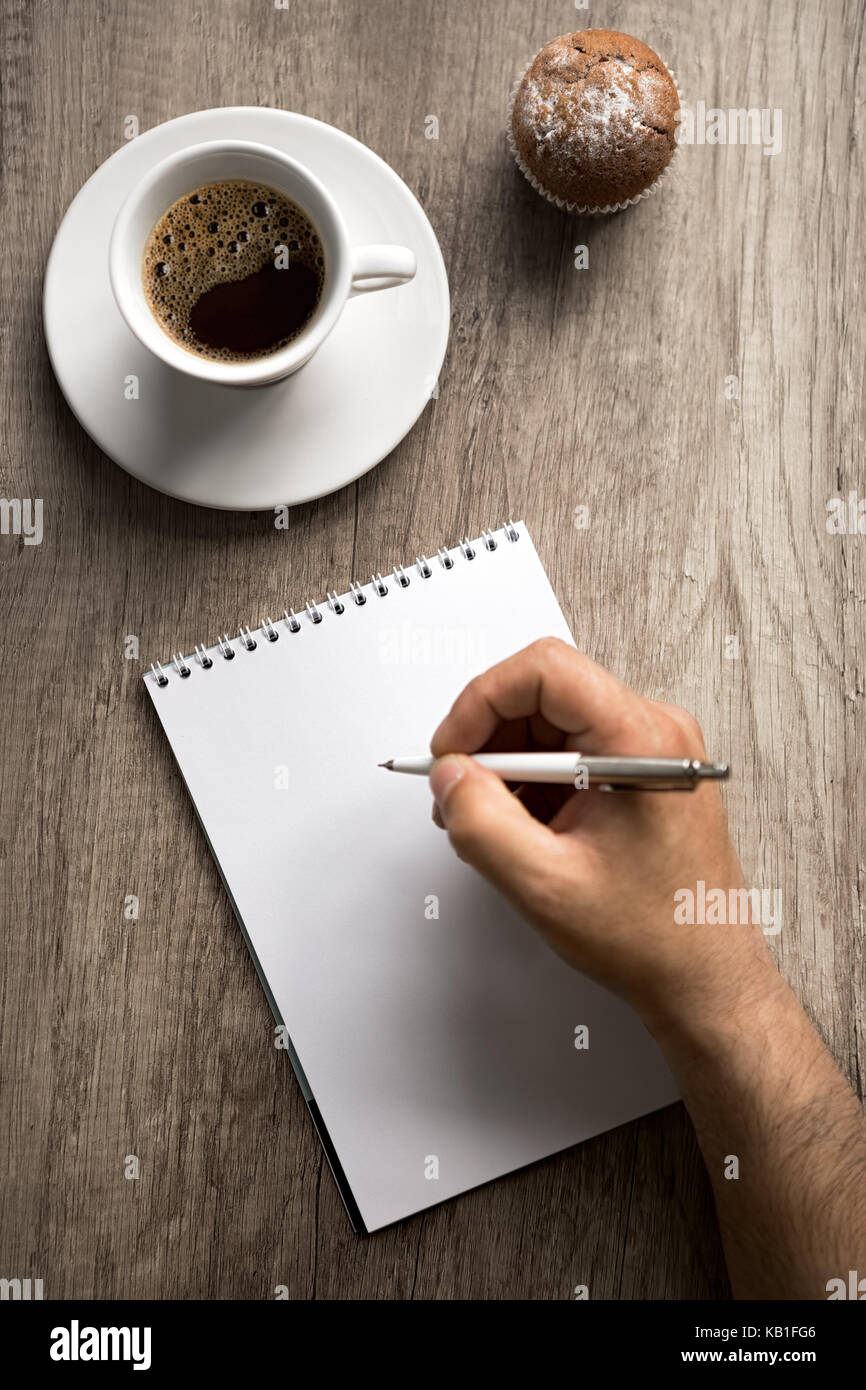 Male hand with pen on empty paper, writing on coffee break Stock Photo