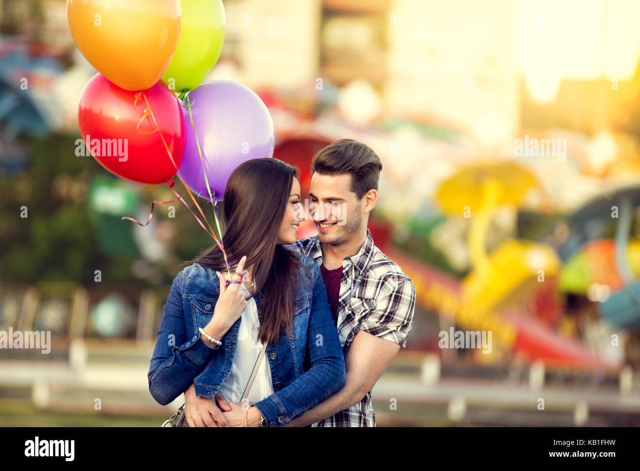 Romantic couple with balloons in the amusement park Stock Photo - Alamy