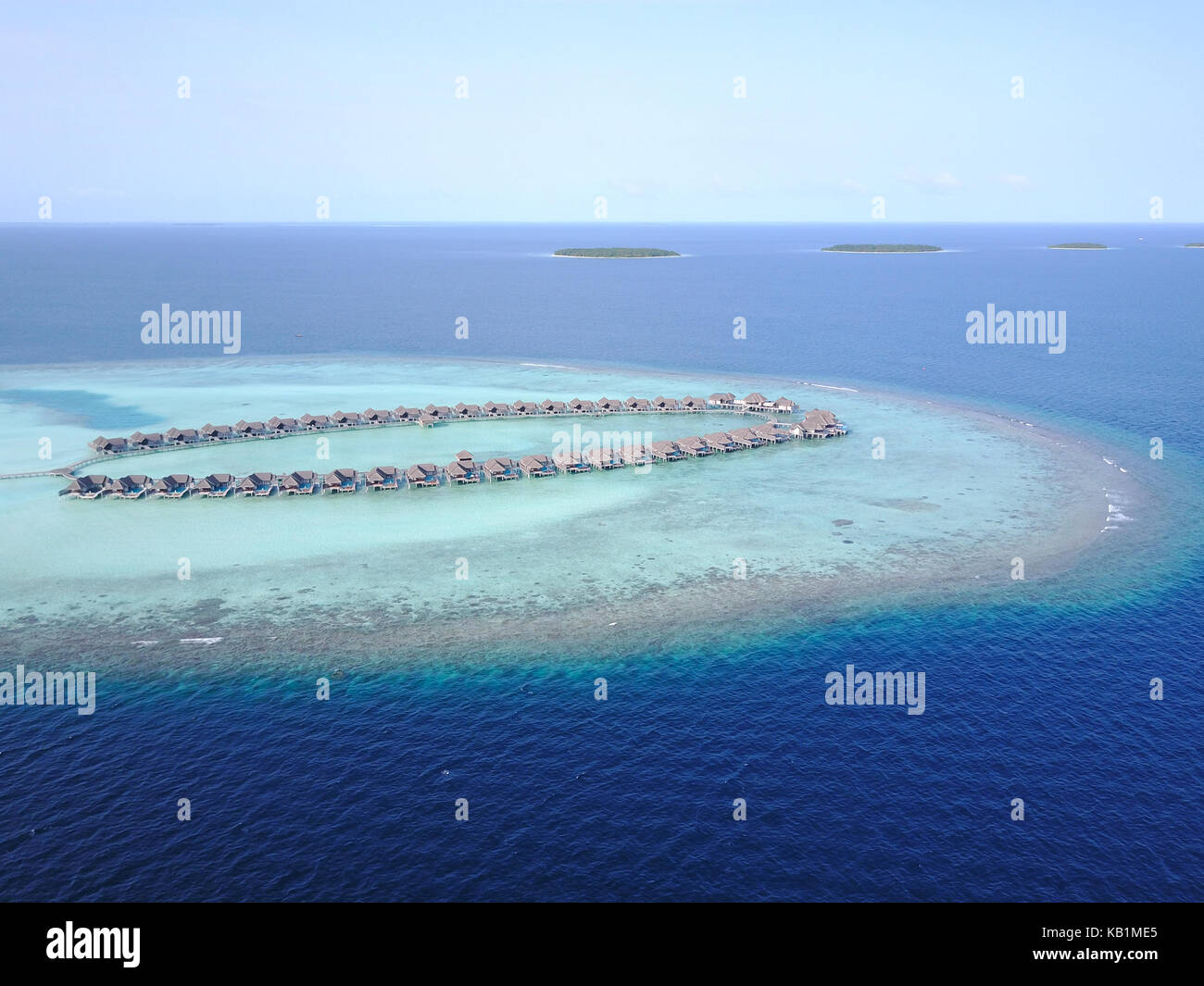 Aerial view of a tropical paradise resort on the edge of a coral reef ...