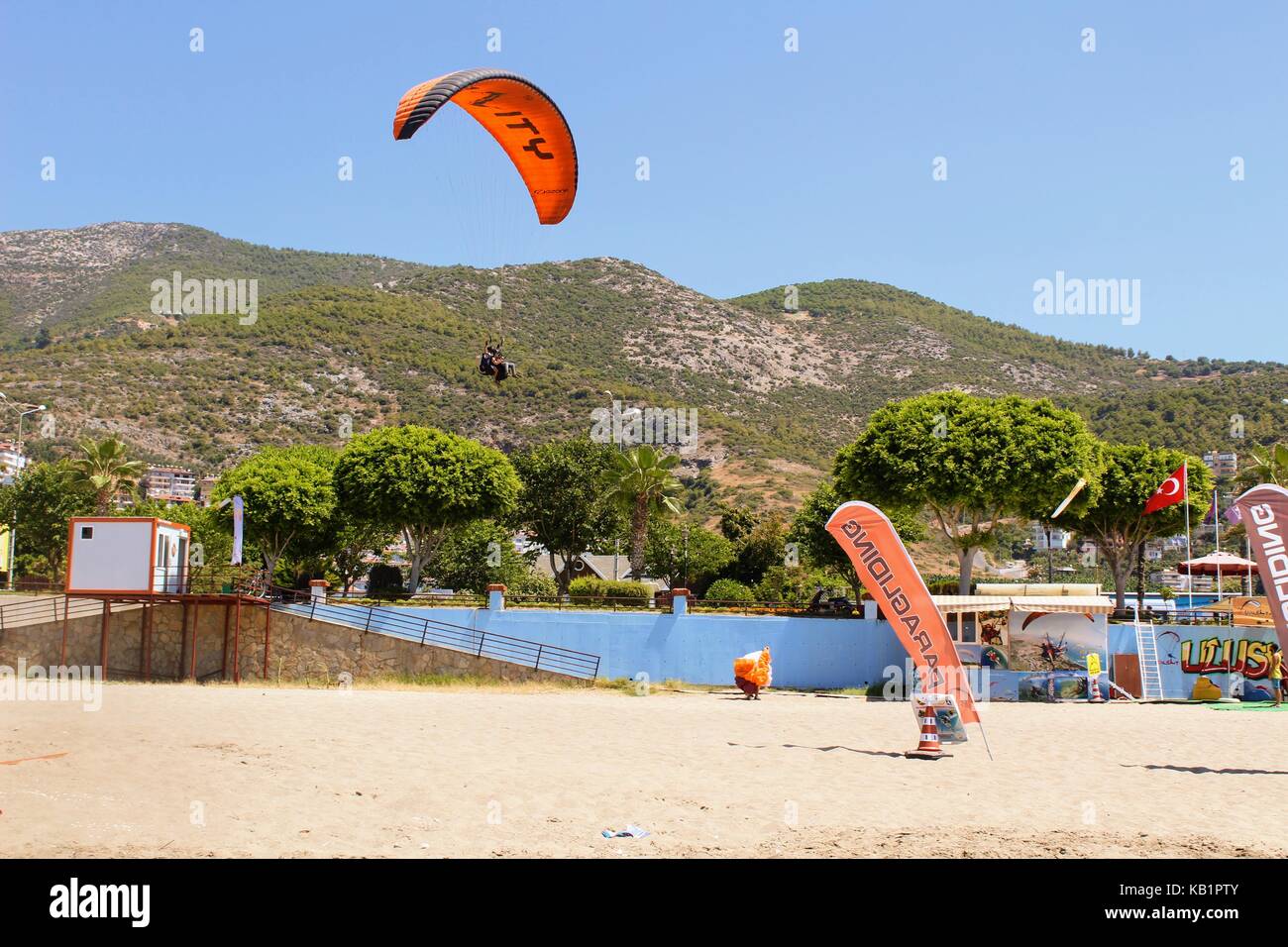Paraglider landing in a special zone at Cleopatra Beach in Alanya (Turkey). Stock Photo