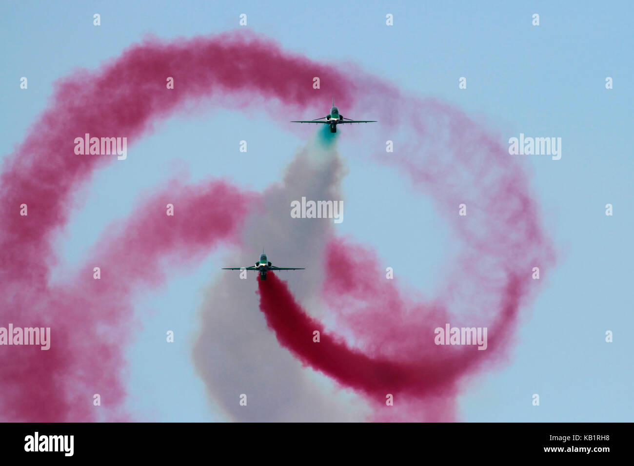 A British Aerospace Hawk of the Saudi Hawks aerobatic team barrel-rolls around another during an air display Stock Photo