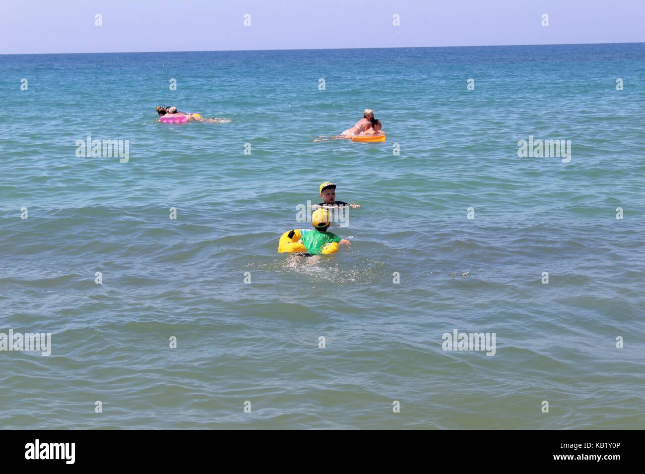 July, 2017 - Vacationers with inflatable mattresses swim in the sea at Cleopatra Beach (Alanya, Turkey). Stock Photo