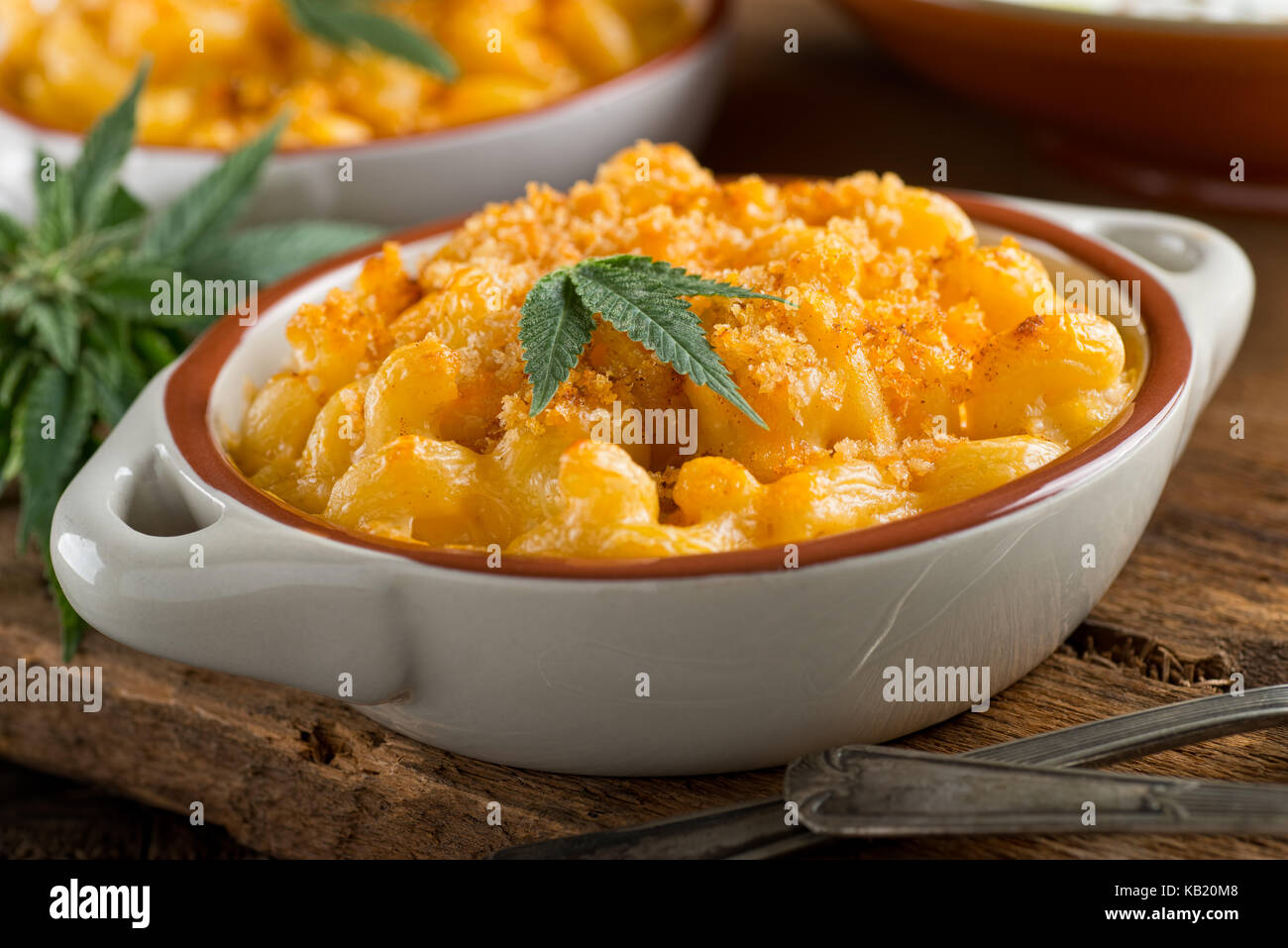 A bowl of delicious homemade weed mac and cheese with marijuana leaf garnish. Stock Photo
