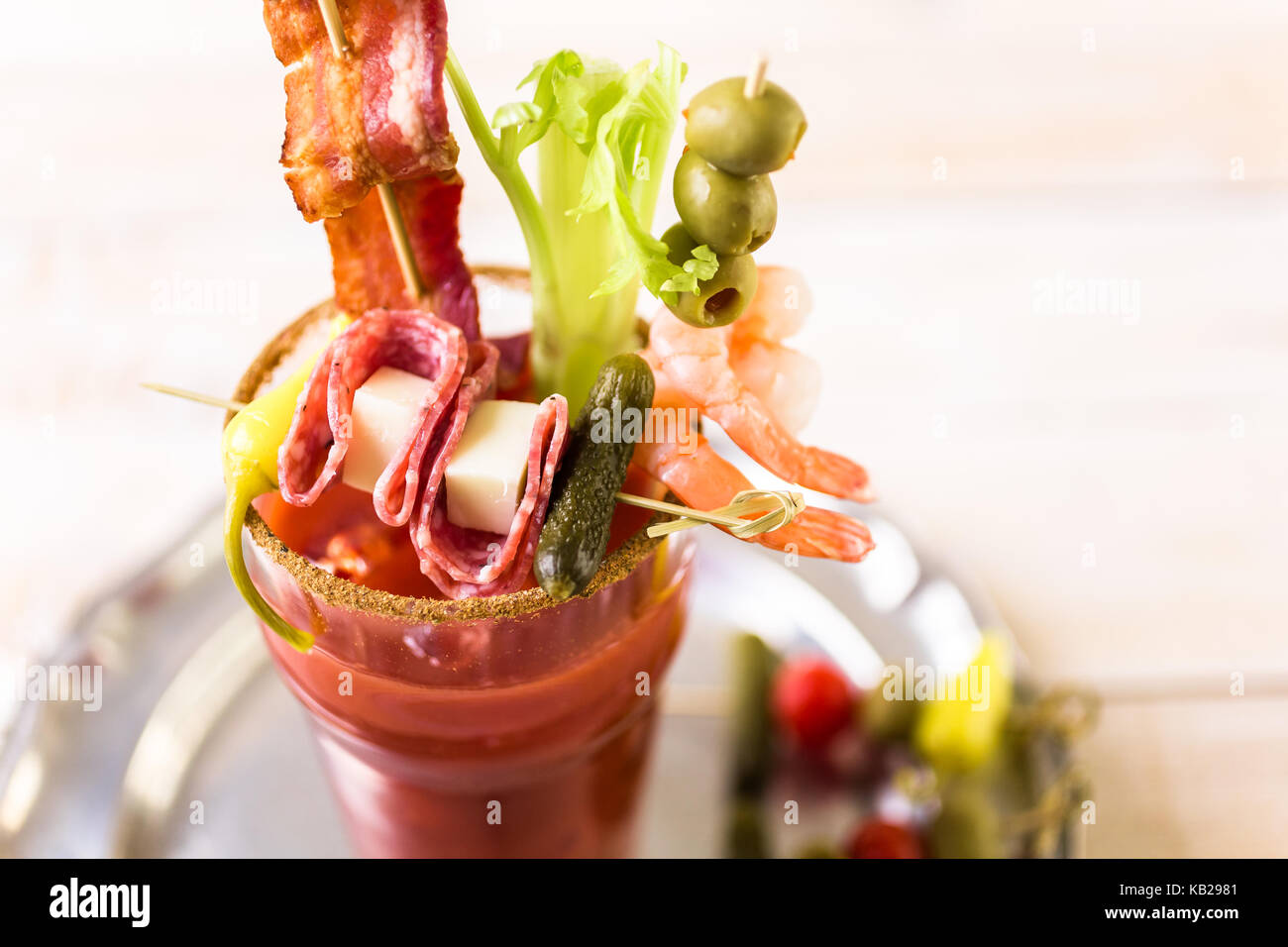 Bloody mary cocktail garnished with celery sticks, olives, and bacon