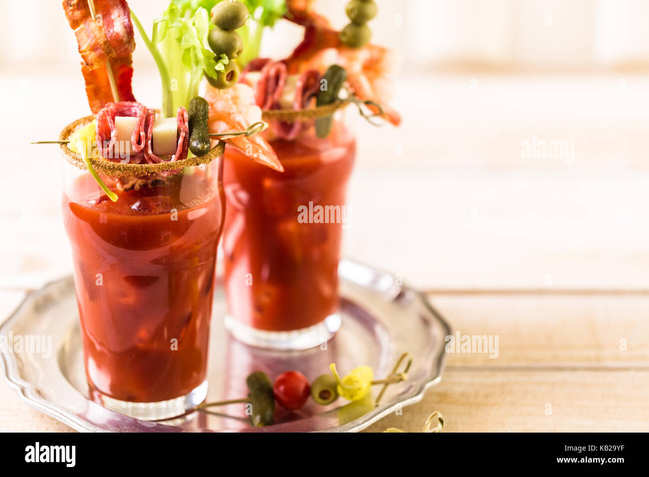 Bloody mary cocktail garnished with celery sticks, olives, and bacon