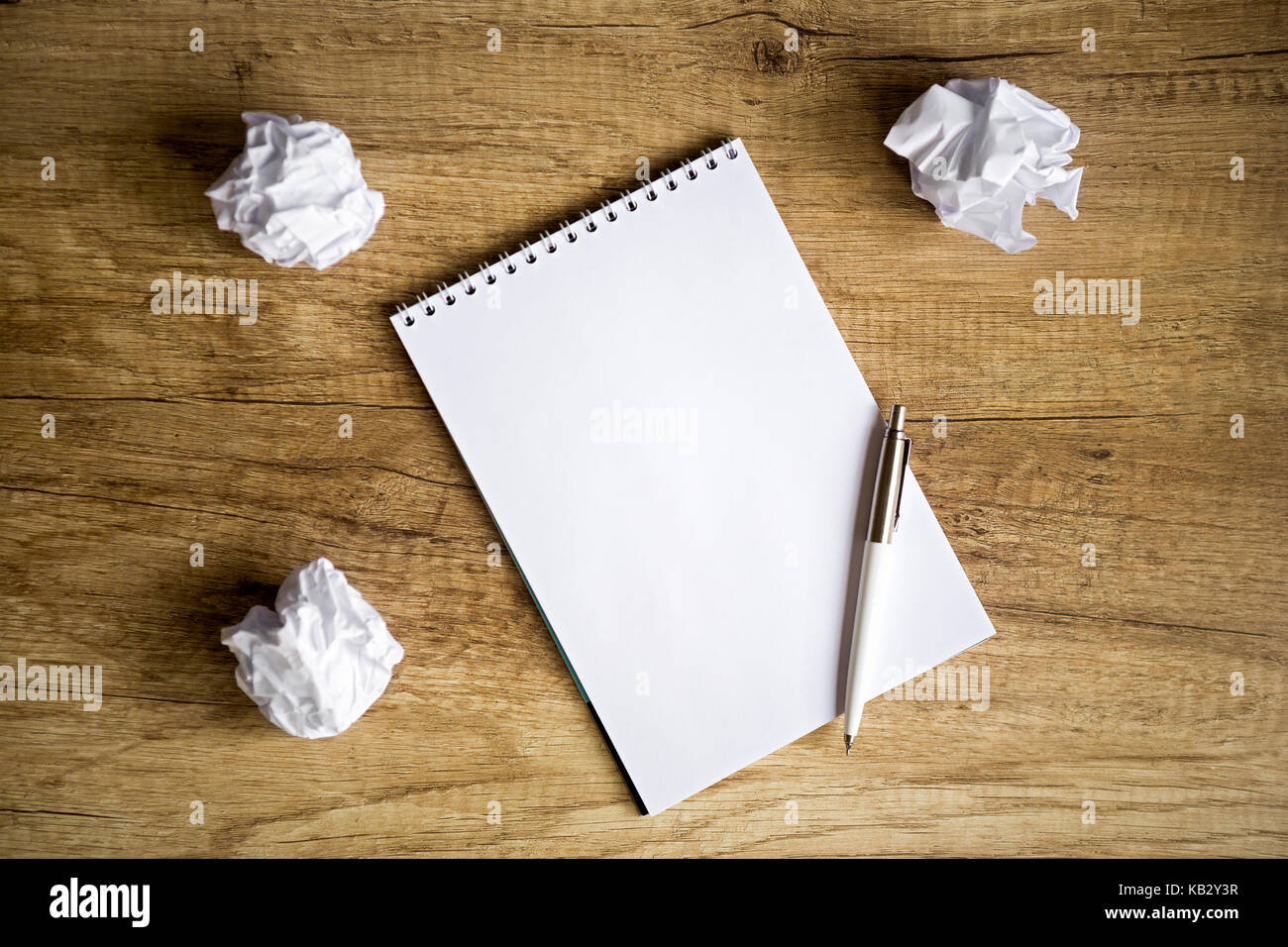 concept - no idea , Empty notebook on wooden table with crumpled papers around Stock Photo