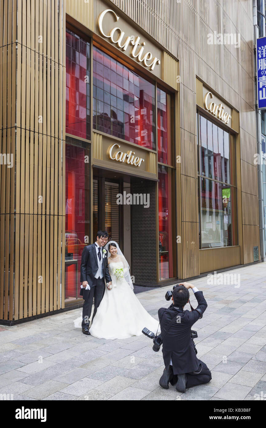 Japan, Honshu, Tokyo, Ginza, bride and groom poses in front of Cartier business, photographer, Stock Photo
