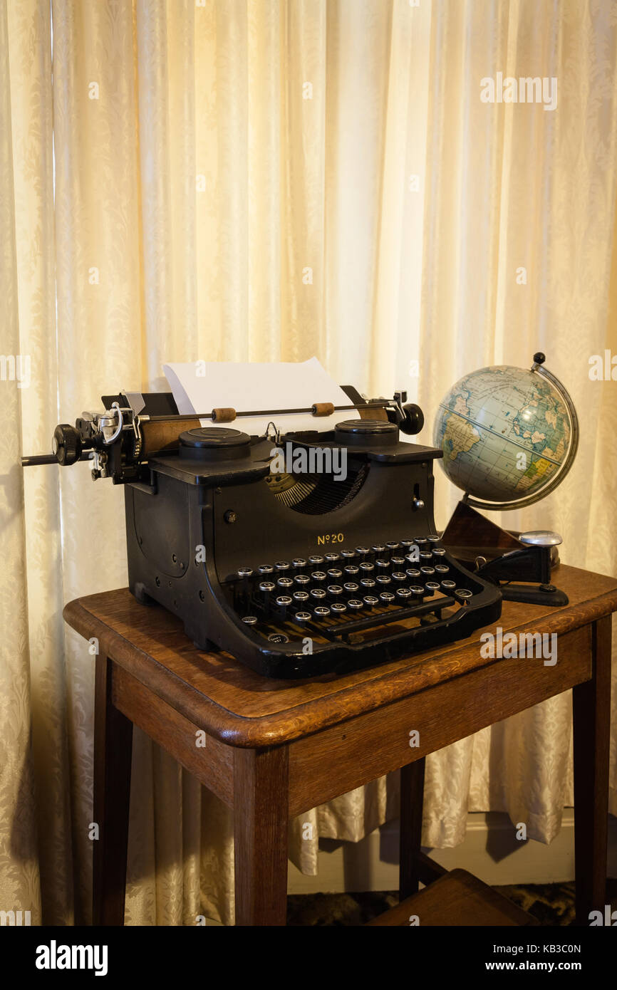 Antique typewriter, globe and stapler on a desk Stock Photo