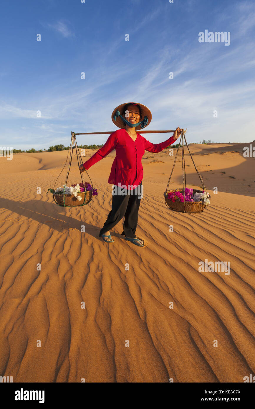 Vietnam, Mui Ne, Sand dune, woman carries costs, Stock Photo
