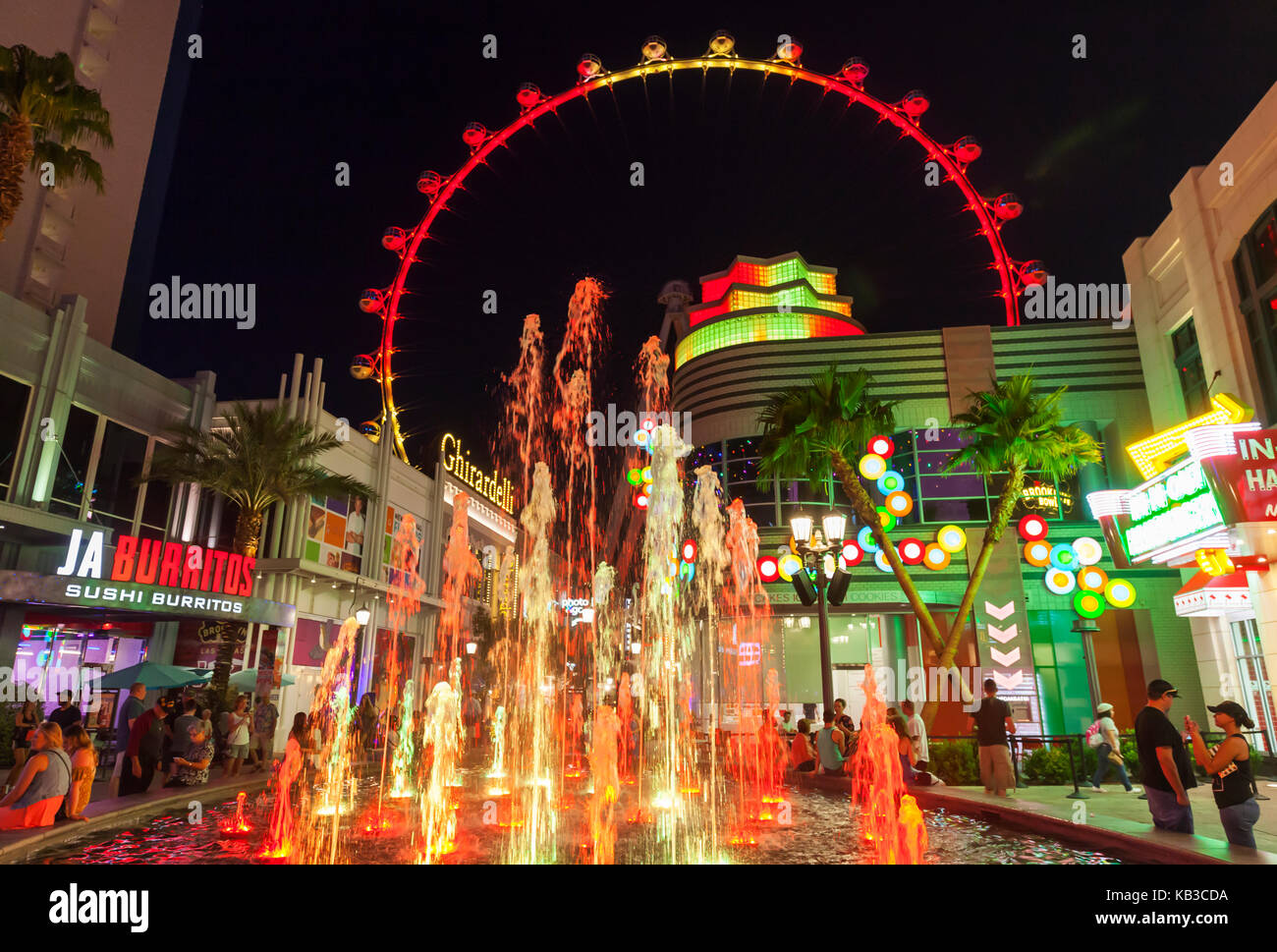Tourists and visitors are enjoying the nighttime walking around the shoppes and stores next to The High Roller in Las Vegas, Nevada. Stock Photo