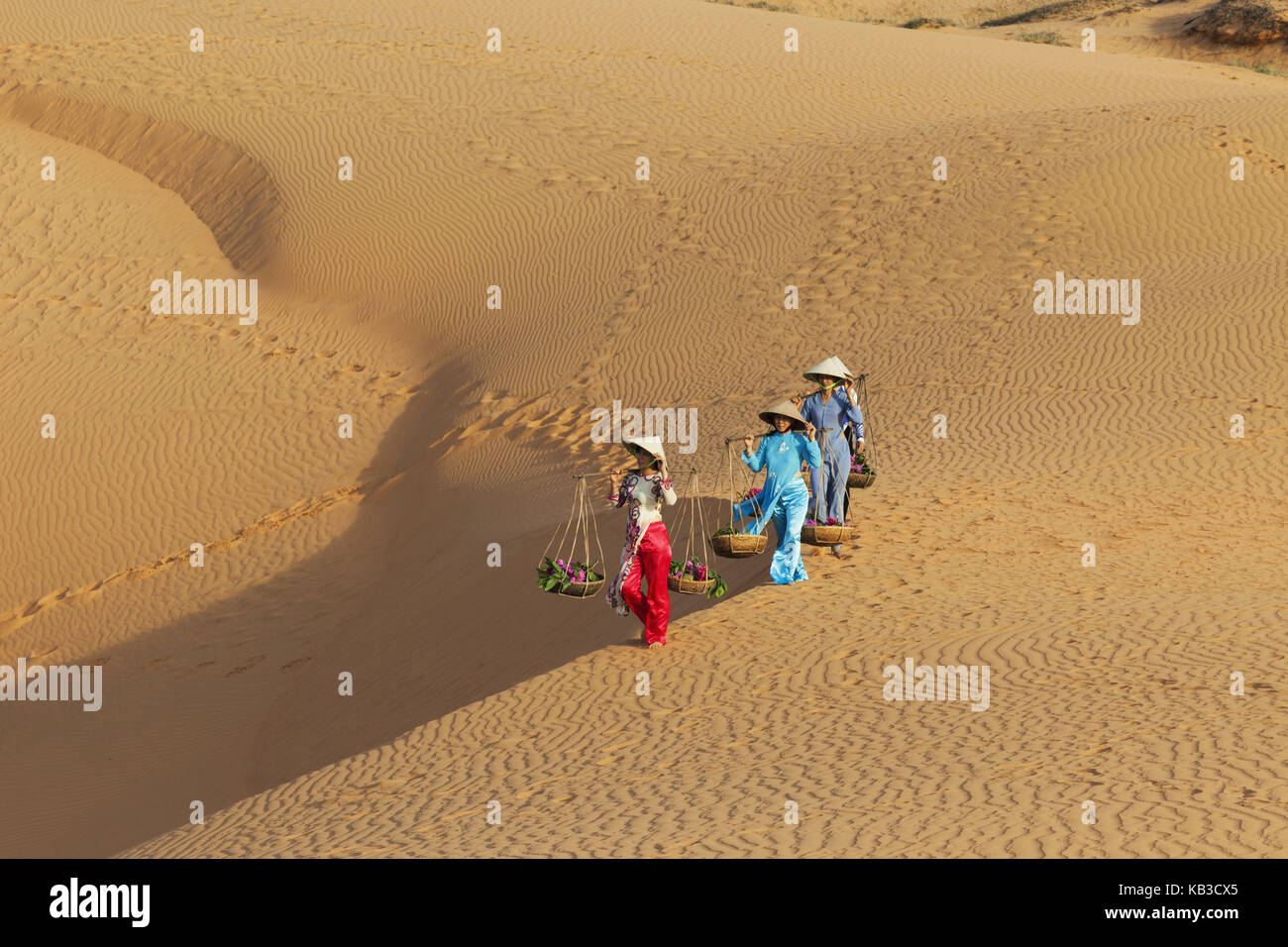 Vietnam, Mui Ne, Sand dune, women carry costs, Stock Photo
