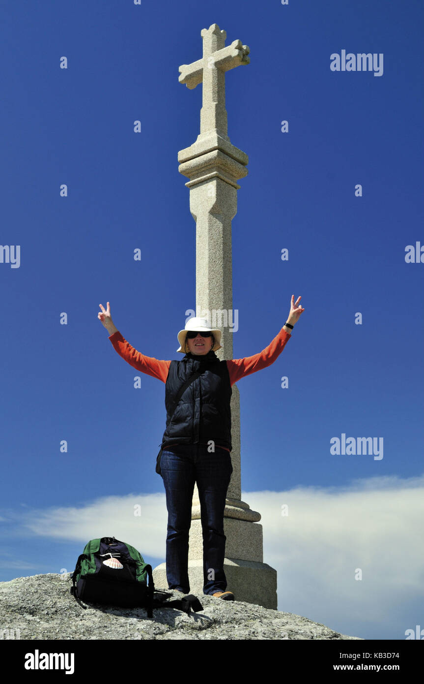 Spain, Way of St. James, pilgrim while arriving on stone cross of the cape Fisterra in Galicia, Stock Photo