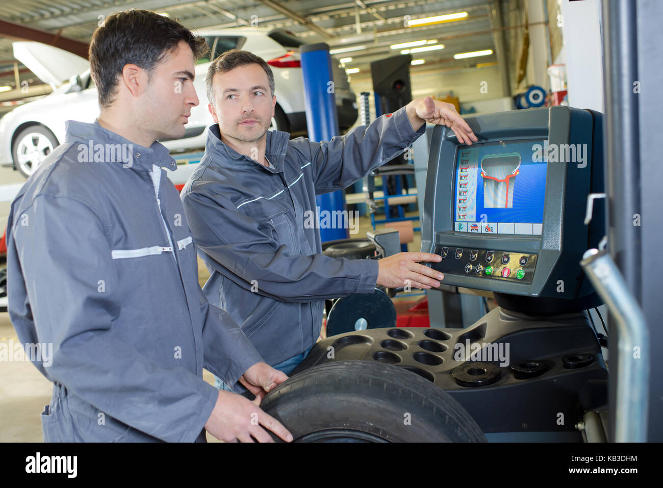 mechanic and apprentice looking at a computer in a garage Stock Photo ...